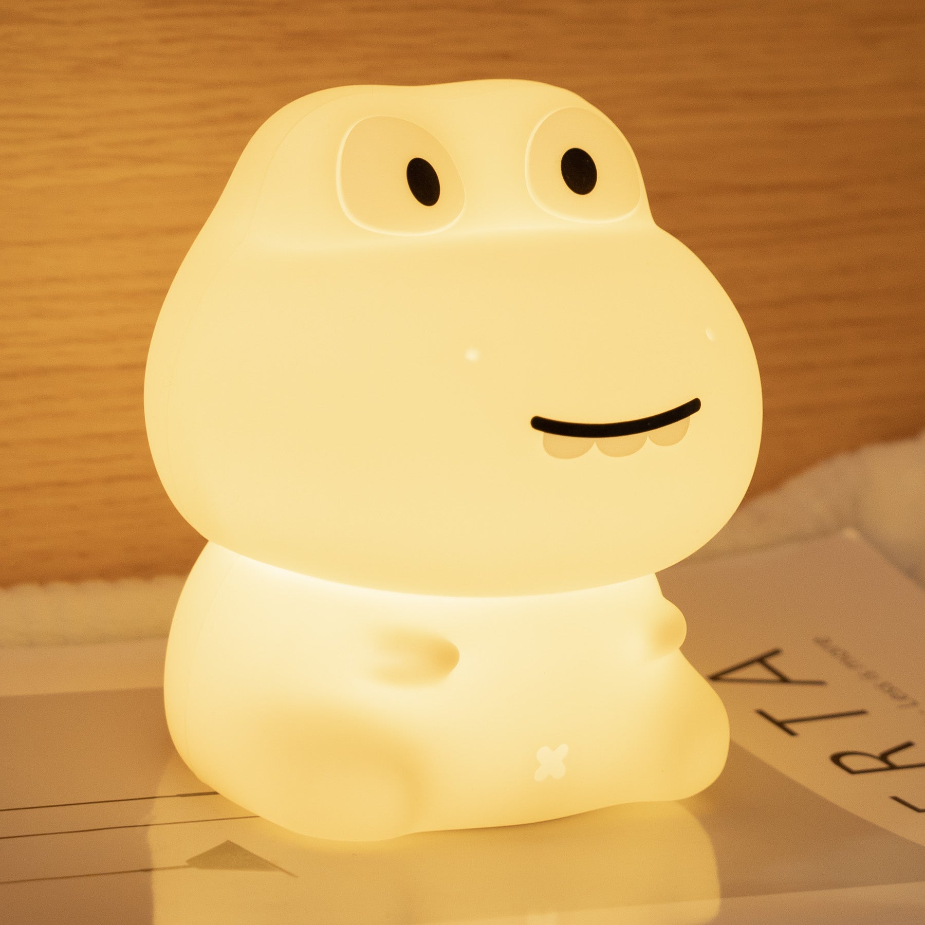 Cute lamp shaped like a cartoon character on a wooden surface