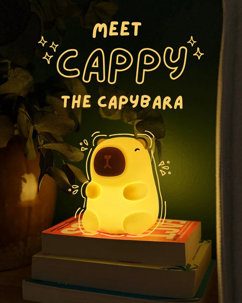 Glowing capybara-shaped night light on books with text 'Meet Cappy the Capybara' in a dark setting.