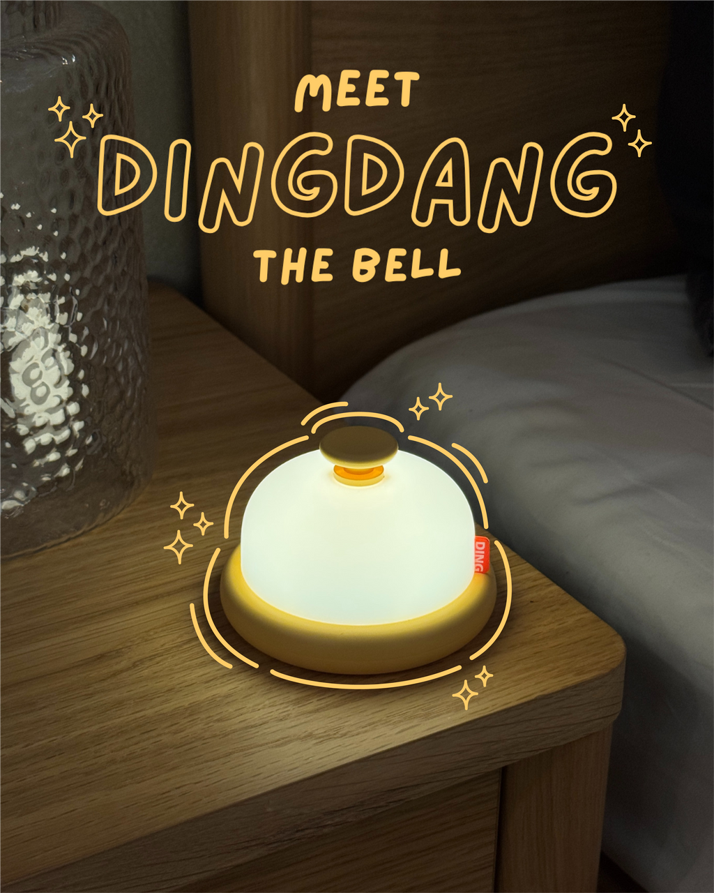 Glowing bell-shaped night light on a wooden surface with 'Meet Dingdang the Bell' text.
