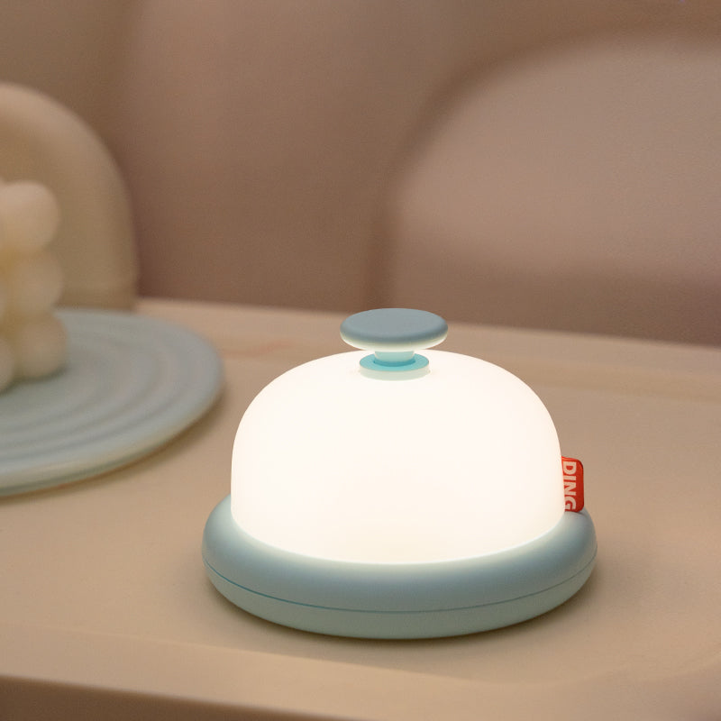 Cute blue bell looking night light on a beige surface.