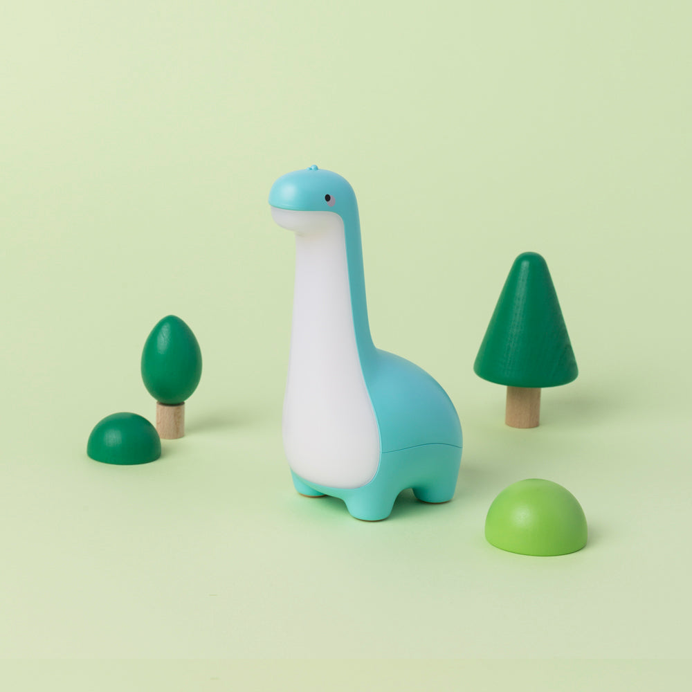 Dinosaur night light with small trees on a light green background