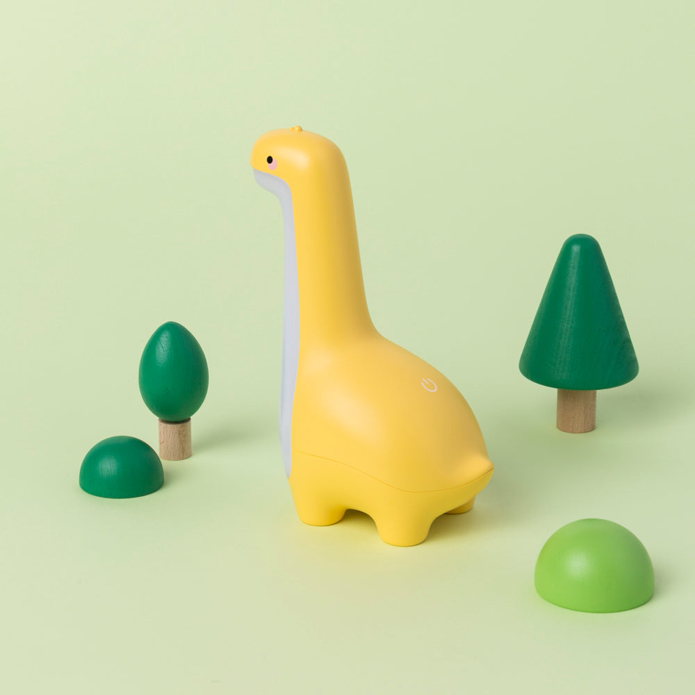 Yellow dinosaur night light with green trees on a light green background