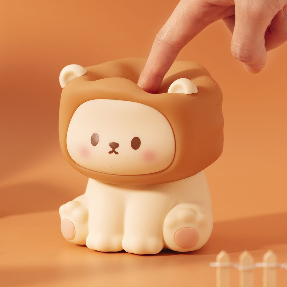 Cute lion-shaped night light with a hand interacting with it on an orange background