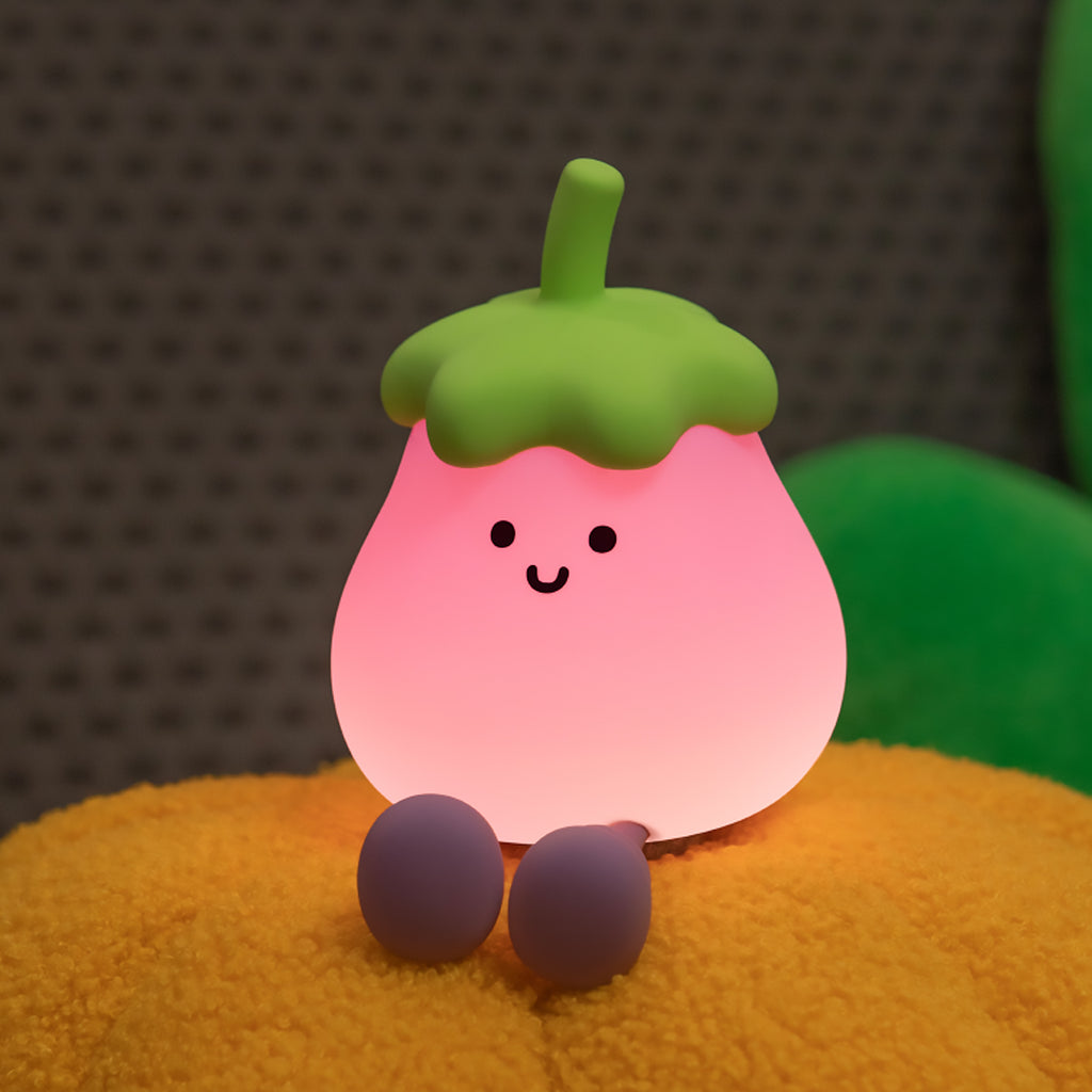 Pink eggplant plush night light with green top on a textured surface
