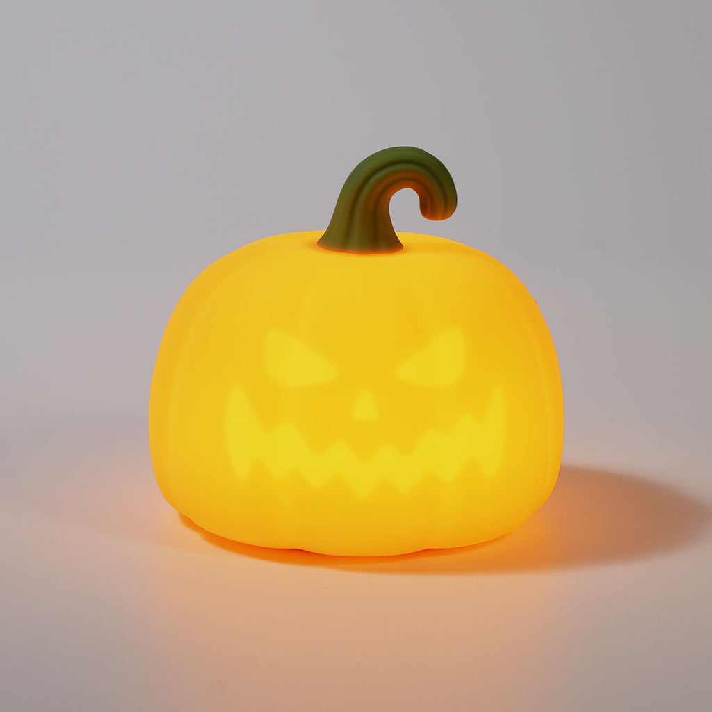Yellow pumpkin-shaped object with a green stem on a gray background