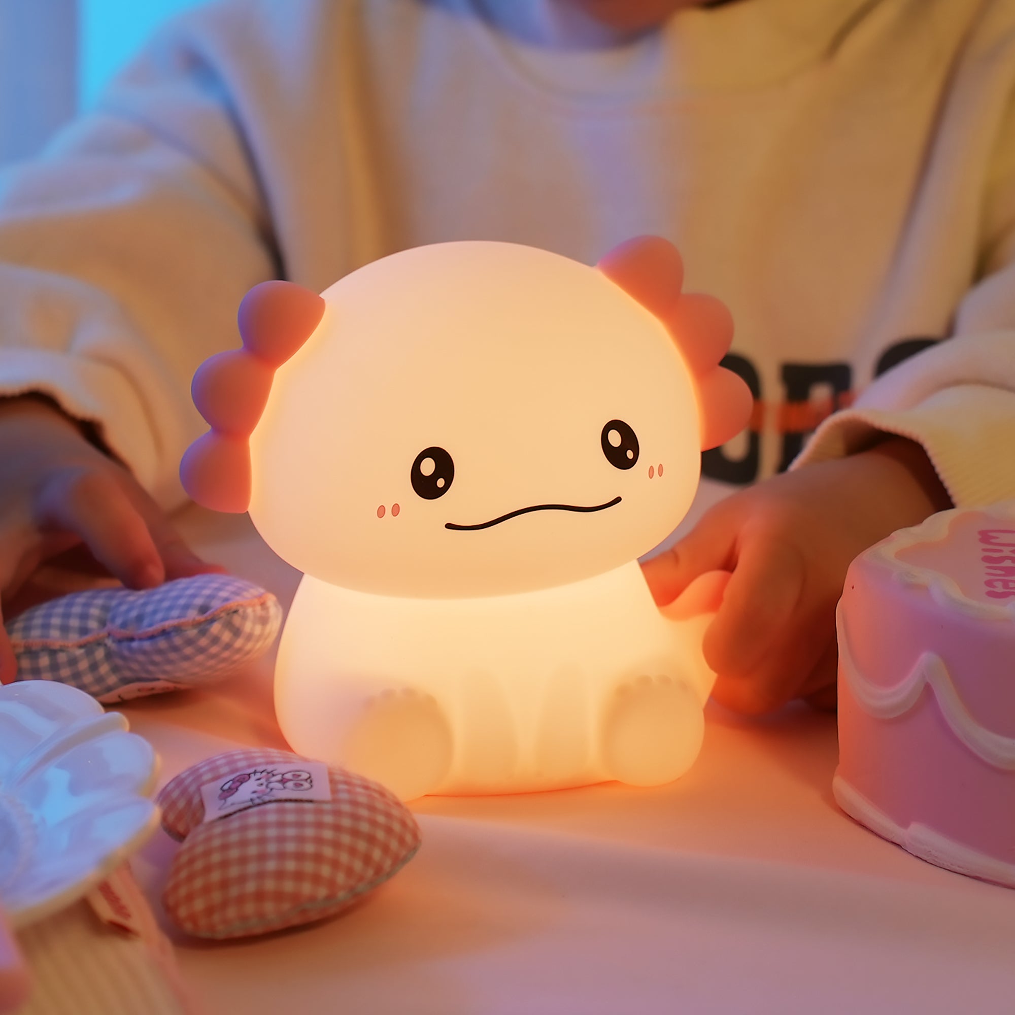 Cute cartoon-style night light held by a child with soft focus background